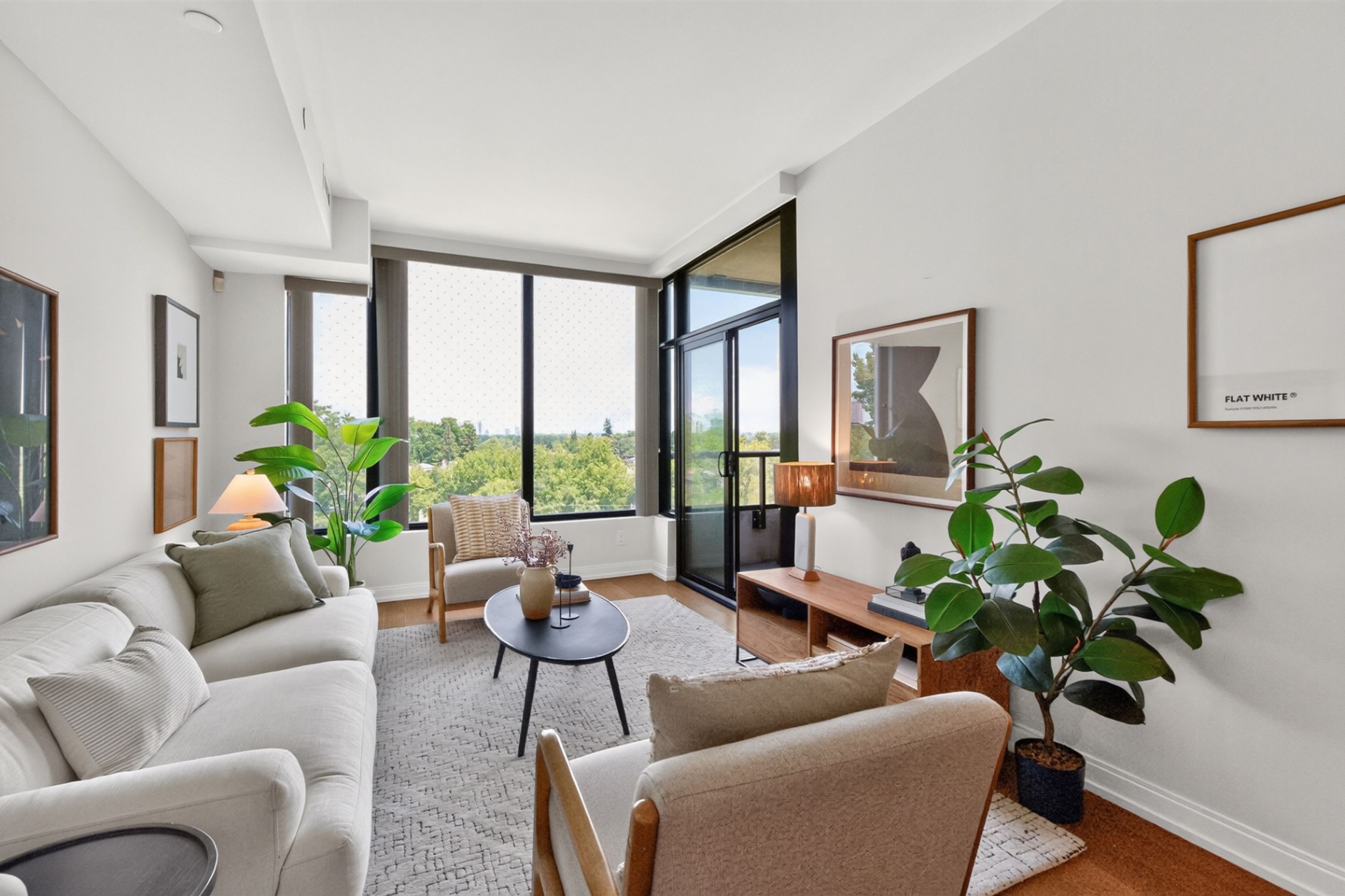 Living room with balcony access and treetop views